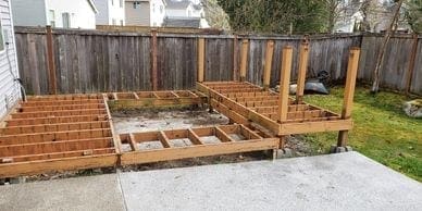 A backyard deck construction project is underway, using wooden materials.