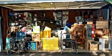 A cluttered garage filled with an excessive amount of items in need of junk removal.