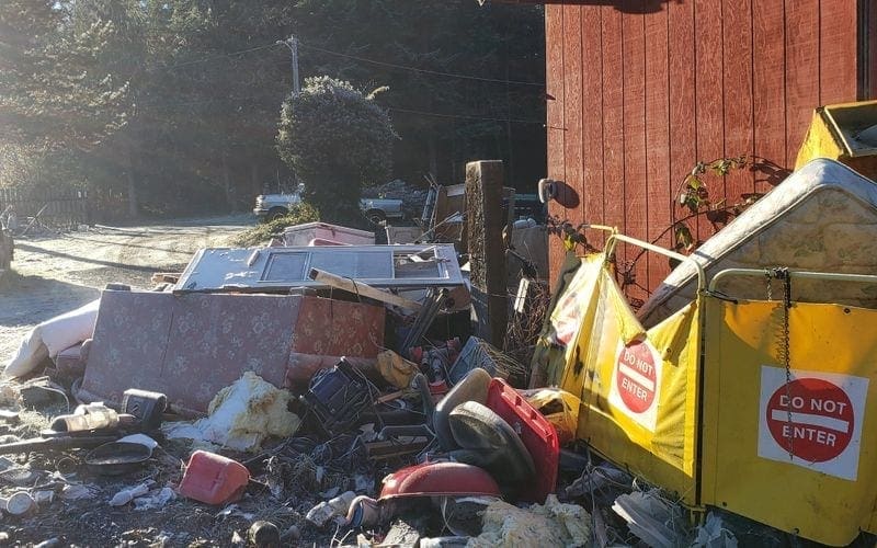 A messy accumulation of waste in front of a house, requiring immediate trash removal in WA.
