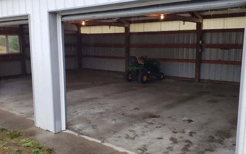 A garage with a tractor parked in it, ready for trash removal in WA.