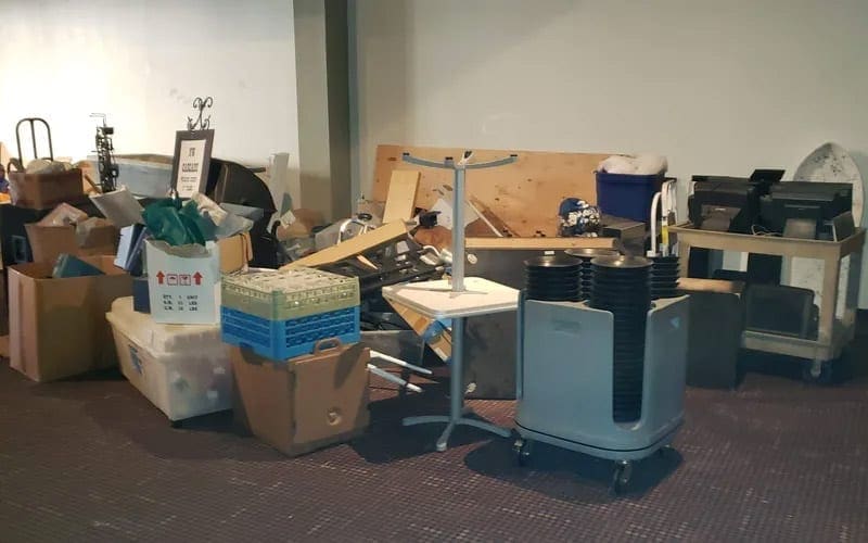 A cluttered room filled with boxes and furniture in need of trash removal in WA.