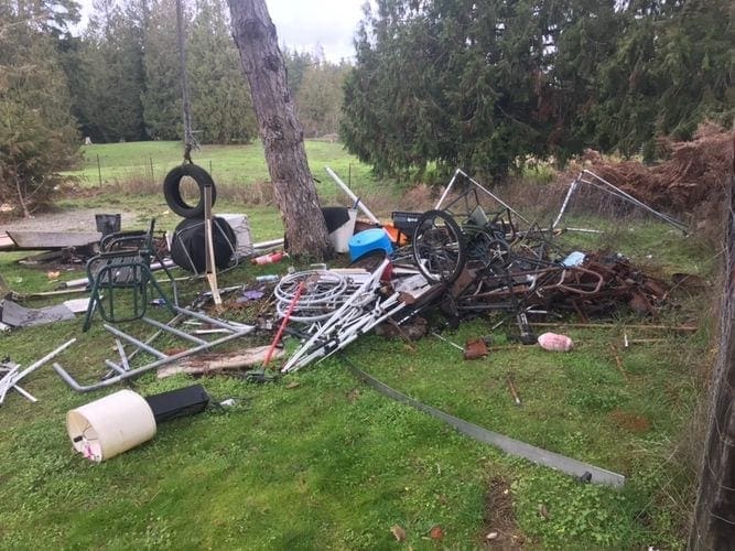 A pile of scrap metal in a yard awaiting trash removal services in WA.