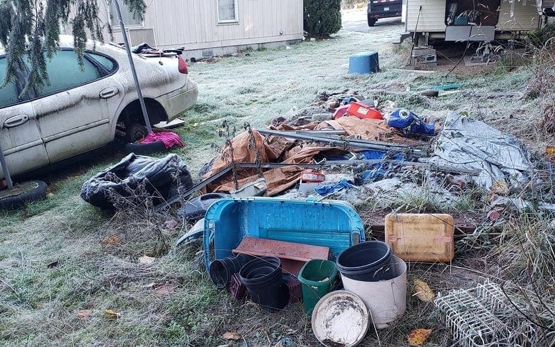 An unsightly pile of garbage in front of a house requiring immediate trash removal in WA.